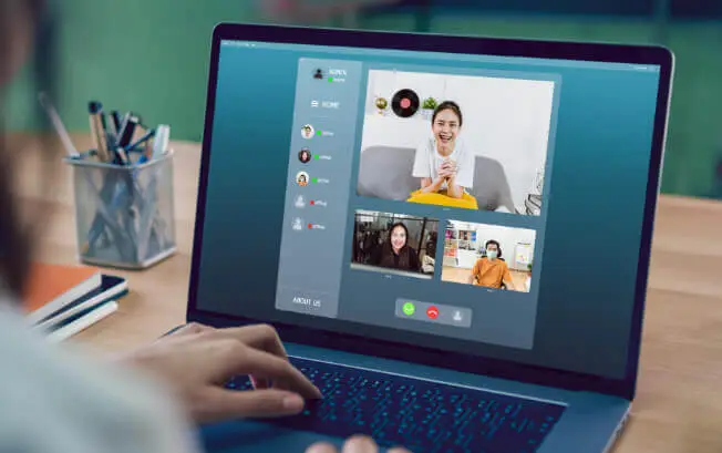 A woman participates a video chat on a laptop.